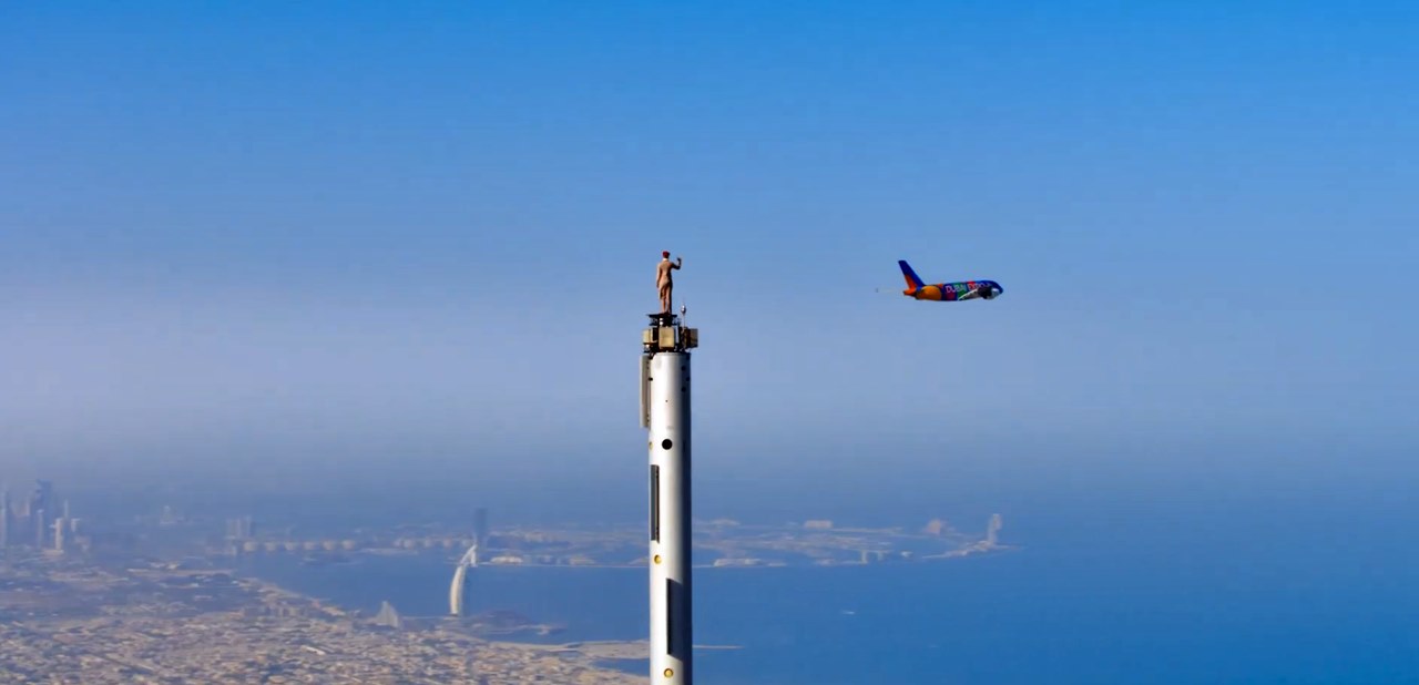 emirates crew on burj khalifa waving at dubai expo plane