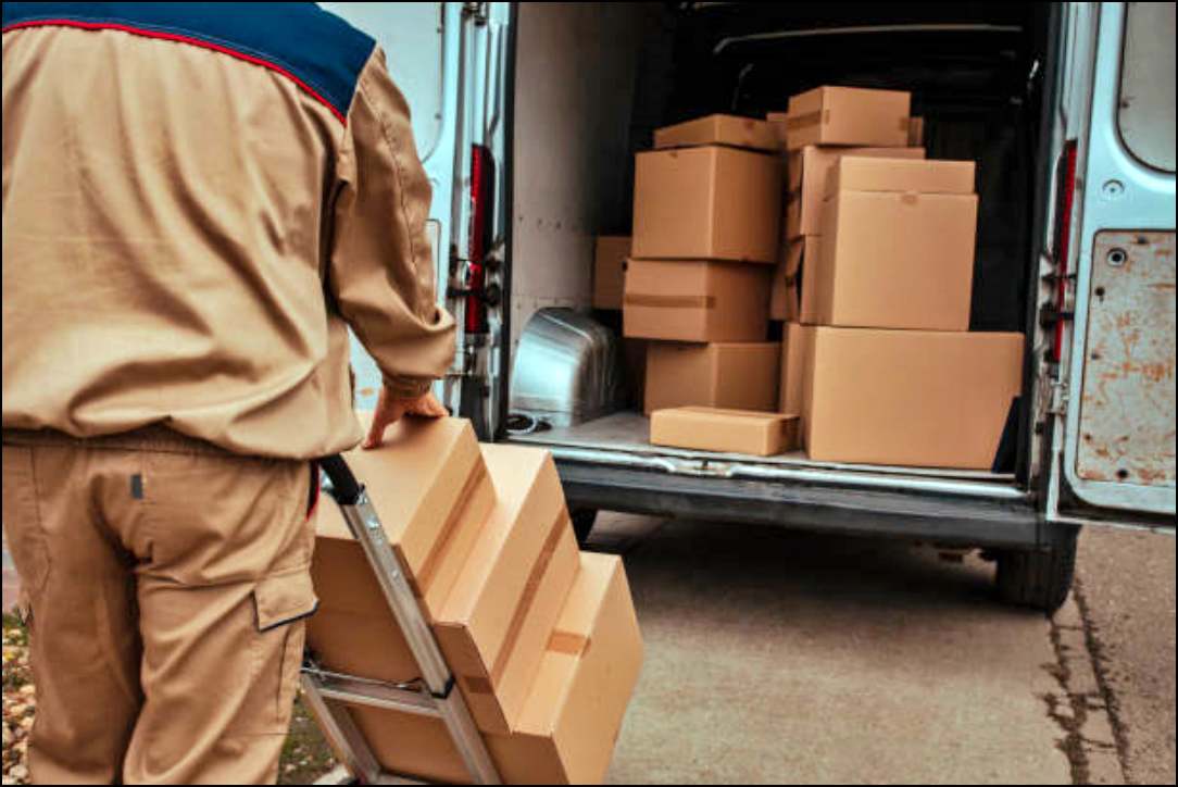 Courier packing cardboard boxes in van and preparing them for delivery